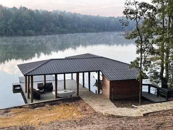 Boathouse and dock on Lake Martin with trees reflecting off the water