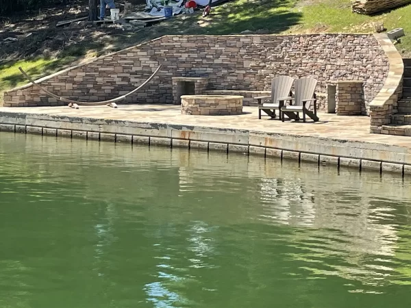 Encircled fire pit with seating, viewed from across the water